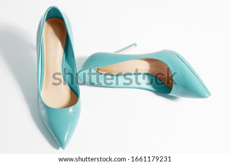 Closeup women patent leather shoes isolated on white background. Stilettos shoe type. Summer fashion and shopping concept. Luxury and glamour party ladies wardrobe accessory. Selective focus