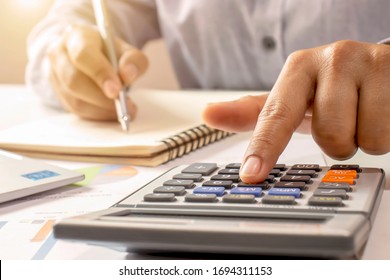 Close-up of women using calculators and note-taking, accounting reports, cost-calculation ideas and saving money.