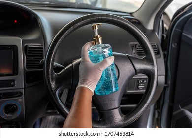 Closeup Of Women's Hands Holding A Hand Sanitizer Gel Bottle For Disinfecting Steering Wheel In A Car.Antiseptic,disinfection ,cleanliness And Healthcare,Anti Bacterial And Corona Virus (COVID-19)