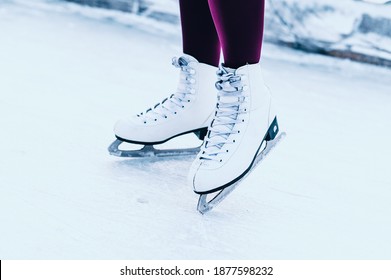 Close-up of women's legs on skates in winter on an open skating rink. Winter time. Place for text