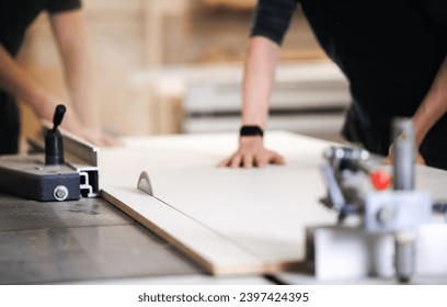 Closeup of wood cut table with electric circular saw for chipboard for furniture production. Professional carpenter cutting wooden board at sawmill. - Powered by Shutterstock