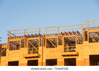 Close-up Wood Framing Multi-storey Apartment Complex Under Construction In Huntsville, Texas, USA. Framing Of Typical Multifamily/student Housing With Garage-wrap Project At Sunset.