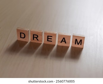 A close-up of wooden blocks spelling DREAM in a minimalist setting inspiring creativity and motivation. - Powered by Shutterstock