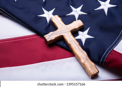 Close-up Of Wooden Christian Cross On American Flag