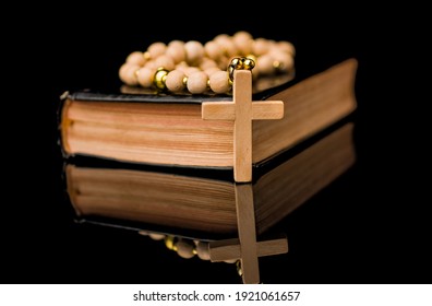 Closeup Of Wooden Christian Cross On Bible And Prayer Beads On B