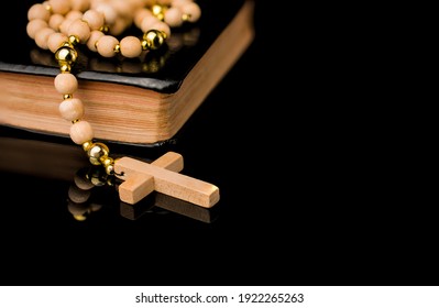 Closeup Of Wooden Christian Cross On Bible And Prayer Beads On B