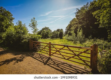A closeup of a wooden fence gate at the farm in the summer countryside