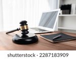 Closeup wooden gavel hammer with laptop and book and pen on desk on wooden office table background as justice legal system for lawyer and judge, Symbolize authority and fairness in trial. equility