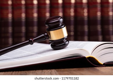 Close-up Of Wooden Gavel On Open Law Book