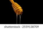 A close-up of a wooden honey dipper dripping with golden honey. The dipper is made of warm, honey-colored wood, and the honey itself is thick and viscous, with a deep amber hue.