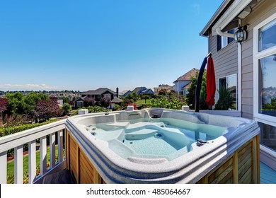 Close-up Of Wooden Hot Tub. Luxury House Exterior. Blue Sky Background. Northwest, USA