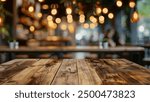 A close-up of a wooden table top with a blurred background of warm cafe lights, creating a cozy and inviting ambiance.