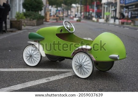 Closeup of wooden vintage car for children parked in the street