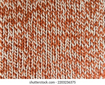 Closeup Woolen Knitted Sweater, Macro Texture Background In Orange Color. Autumn Vibes, Pumpkin Spice Colors. Knitted Wallpaper. Fall Knitted Fabric. Knitted Texture. Soft Material.