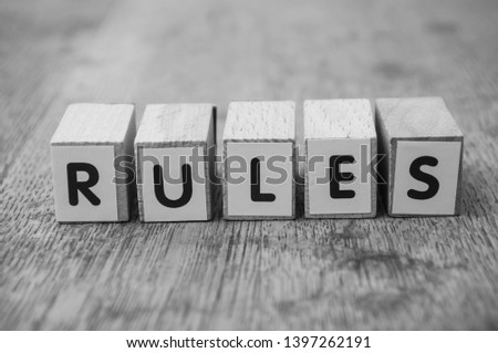 Closeup of word on wooden cube on wooden desk background concept - Rules