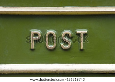 Close-up of the word POST on a traditional Victorian post box in the UK.