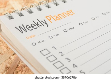close-up word weekly planner on wooden background