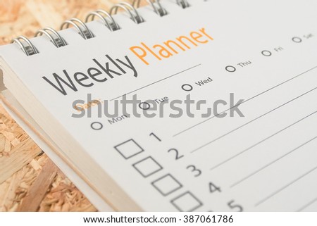 close-up word weekly planner on wooden background