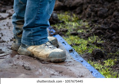 Closeup Of Work Boots On Tarp Next To Soil