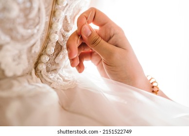 Close-up of work process of a tailor in her studio. Clothes shop for wedding dresses. Designer hands sewing wedding dress. Hands of woman sew beads and white lace on mannequin or bride. - Powered by Shutterstock