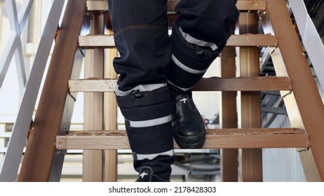 Close-up of a worker descending from a metal ladder in an industrial building in special safety shoes. Work at hazardous facilities, the worker goes down the stairs. Factory worker concept. - Shutterstock ID 2178428303
