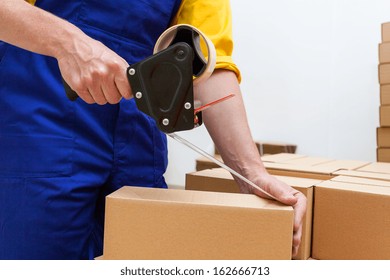 Closeup Of A Worker Hands Packing A Box