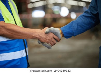 closeup worker shaking hands with coworker before starting work in the factory - Powered by Shutterstock