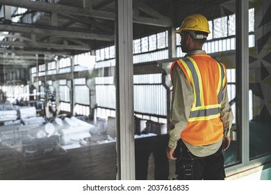 A closeup of the worker standing in front of the windows and looking inside 