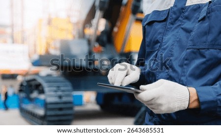 Close-up of worker with tablet in modern mining facility, technology in industrial operations.