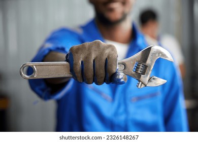 closeup worker or technician hands holding wrench and fist bump pose in the factory