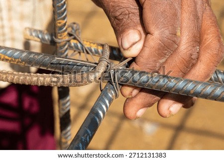 Closeup of Worker Tying Intersecting Rebar Rods