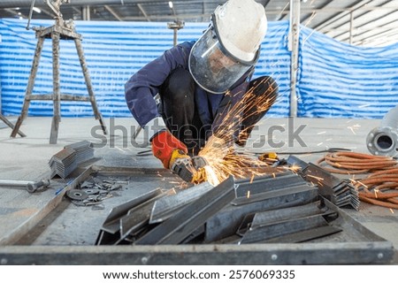 Close-up of a worker using an angle grinder to cut metal, with bright orange sparks flying, showcasing precision in metalworking.