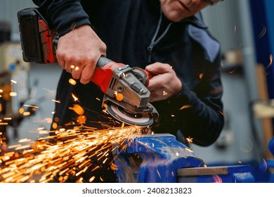 Close-up of a worker using an electric wheel grinding in a factory - Powered by Shutterstock