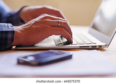 Close-up of a worker using a laptop computer.