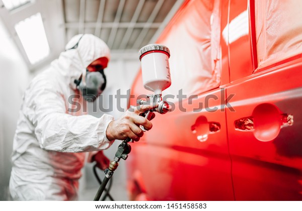 スプレーガンとエアブラシを使用し 赤い車を塗装する労働者の接写 の写真素材 今すぐ編集