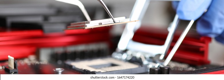 Close-up Of Workers Hands Repair Computer. Man Putting Cpu On Motherboard. Macro Shot Of Intel Microprocessor In The Socket. Upgrade And Technology Concept