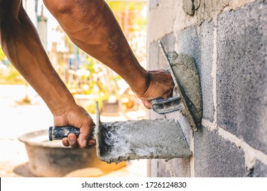 Close-up Of Workers Using Plaster Trowel To Plaster The Walls For House Construction, Working Ideas And Residential Construction.