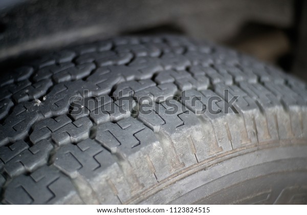 Close-up worn out bald old car tire.\
Care use unsafe tire, not safe for use. Old, damaged and worn black\
tire tread. Tire tread problems and solutions\
concept.