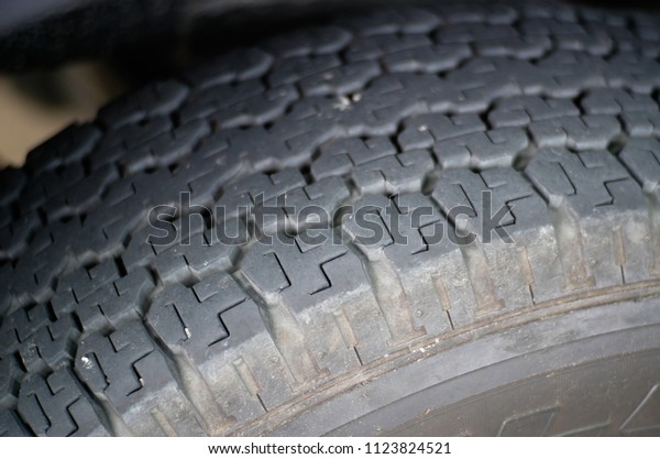 Close-up worn out bald old car tire.\
Care use unsafe tire, not safe for use. Old, damaged and worn black\
tire tread. Tire tread problems and solutions\
concept.