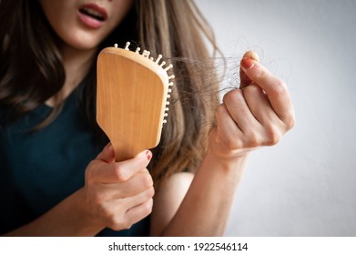 Close-up of worried woman holding comb with hair loss after brushing her hair. Hair loss it cause from family history, hormonal changes, unhealthy of aging.