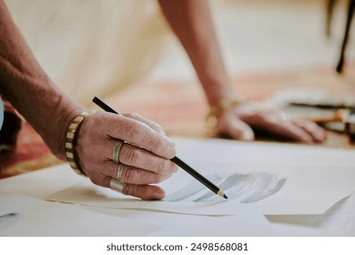 Closeup of wrinkled hand of unrecognizable senior female artist drawing pencil sketch, copy space - Powered by Shutterstock