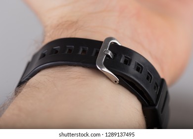 Closeup Of Wrist Watch Clasp On Black Strap.