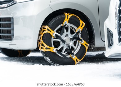 Close-up of yellow chains anti-slip wheel chain. There are fitted to the tires of vehicles to provide maximum traction when driving through snow and ice.