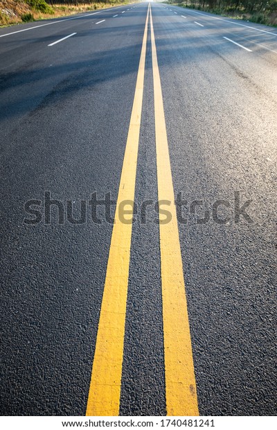 Closeup yellow\
dividing line on asphalt\
road