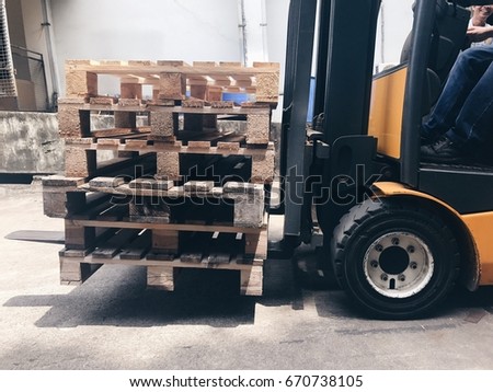 Closeup yellow forklift truck with pallet.