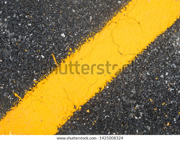 closeup yellow
line on black asphalt
background