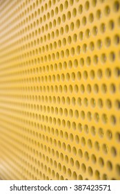 Close-up of yellow metallic sheet with pattern.