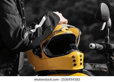 Close-Up of Yellow Motorcycle Helmet and Biker's Hand in Black and White Background - Powered by Shutterstock