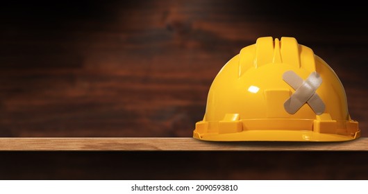 Closeup Of A Yellow Safety Helmet With A Cross Bandaid (adhesive Bandage), Above A Wooden Shelf With Copy Space. Concept Of Construction Industry And Workplace Security.
