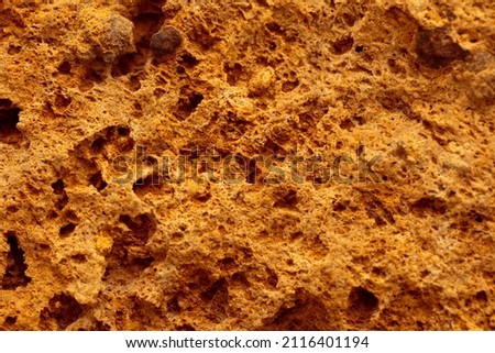 Close-up of a yellow sand stone millstone wall rock detailed texture surface background
